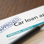 Approved car loan application with pen
