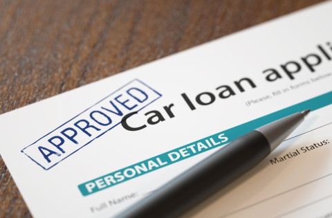 Approved car loan application with pen