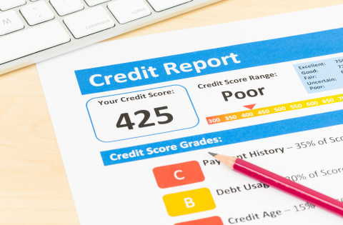 Poor credit score report with pen and keyboard